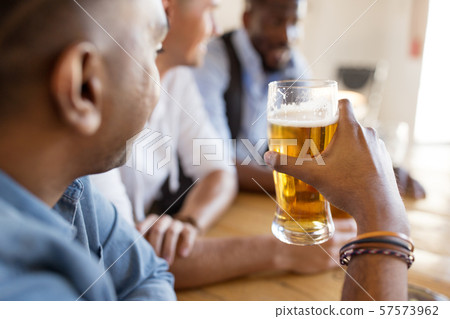 male friends drinking beer at bar or pub male friends drinking beer at bar or pub 57573962