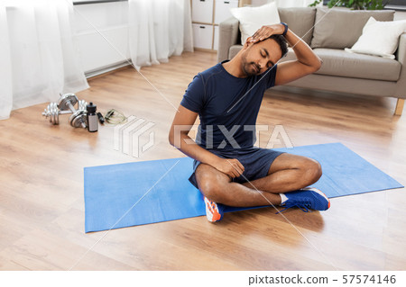 man training and stretching body at home man training and stretching body at home 57574146