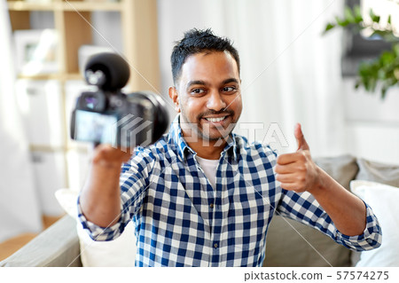 male video blogger with camera blogging at home 57574275