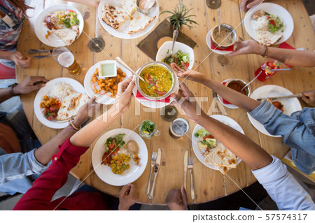 international friends eating at restaurant 57574317