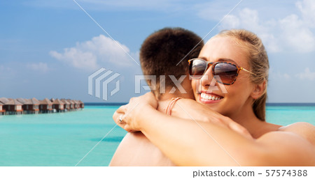 happy couple hugging on summer beach happy couple hugging on summer beach 57574388