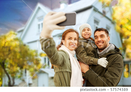 family taking selfie over house in autumn family taking selfie over house in autumn 57574389