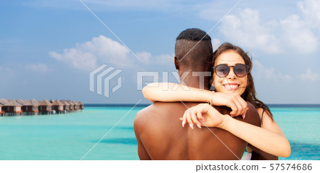happy mixed race couple hugging on summer beach happy mixed race couple hugging on summer beach 57574686