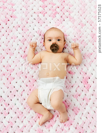 baby girl in diaper lying with pacifier on blanket baby girl in diaper lying with pacifier on blanket 57575028