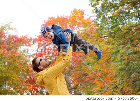 father with son playing and having fun in autumn 57575600