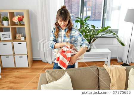 asian woman picking dirty laundry at home 57575633