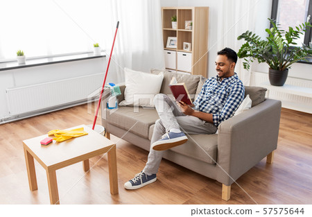 man reading book and resting after home cleaning 57575644