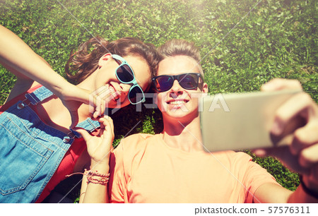 happy couple taking selfie on smartphone at summer happy couple taking selfie on smartphone at summer 57576311