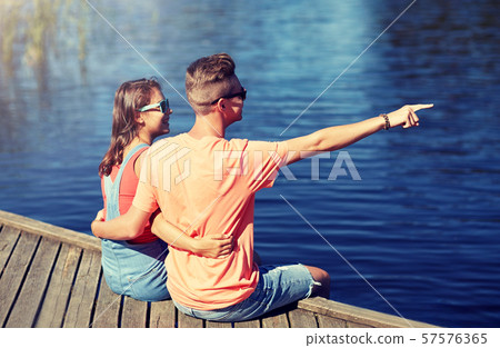 happy couple pointing finger on summer river berth happy couple pointing finger on summer river berth 57576365