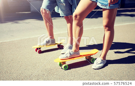 teenage couple riding skateboards on city street teenage couple riding skateboards on city street 57576524