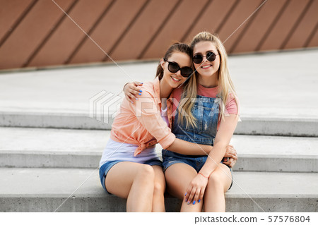 teenage girls or friends on city street in summer 57576804