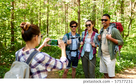 friends with backpacks being photographed on hike 57577231