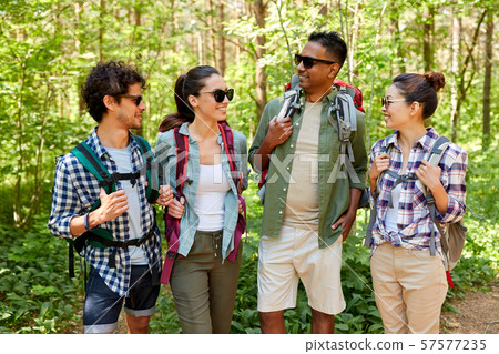 friends with backpacks on hike talking in forest 57577235