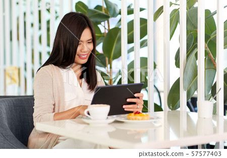 asian woman with tablet pc at cafe or coffee shop asian woman with tablet pc at cafe or coffee shop 57577403