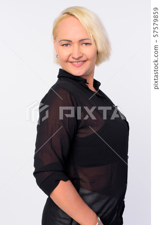 Profile view of happy businesswoman with blond hair looking at camera Profile view of happy businesswoman with blond hair looking at camera 57579859