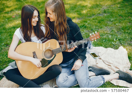 Two girls with a guitar 57580467