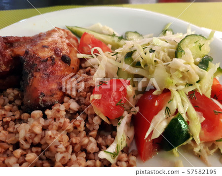 Buckwheat with salad and chicken. Homemade European dinner. Buckwheat with salad and chicken. Homemade European dinner. 57582195