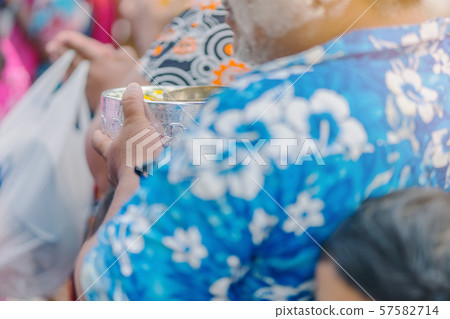 People are holding a bowl of water perfume with flower preparing to shower for the monks on Songkran day.(Thailand New Year) 57582714