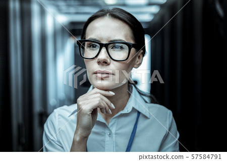 Dark-haired professional from intelligence agency in eyeglasses looking thoughtful Dark-haired professional from intelligence agency in eyeglasses looking thoughtful 57584791
