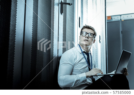 Professional in a blue shirt looking thoughtful Professional in a blue shirt looking thoughtful 57585000
