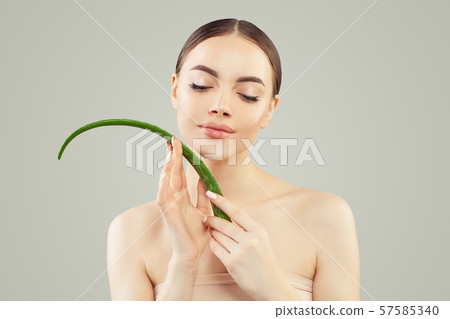 Young spa model woman with clear skin holding aloe 57585340
