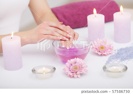 Woman hands receiving a hand scrub peeling by a beautician in beauty salon. SPA manicure, hand 57586730