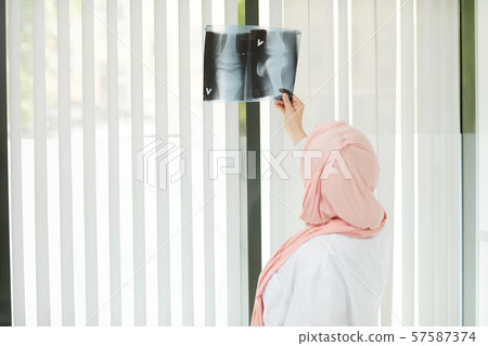 Middle-Eastern Female Doctor Looking at X Ray 57587374