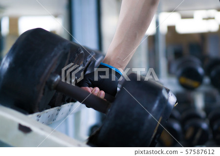 Close up hand taking heavy rusty dumbbell to exercise for strength training. sport, fitness, health, lifestyle and people concept Close up hand taking heavy rusty dumbbell to exercise for strength training. sport, fitness, health, lifestyle and people concept 57587612