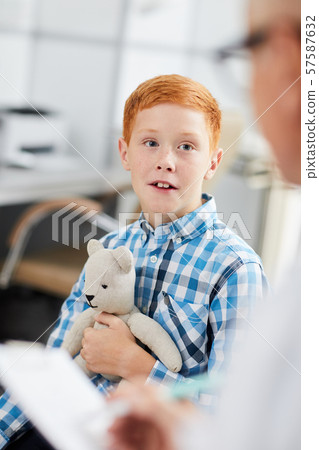 Red-Haired Boy Talking to Doctor 57587632