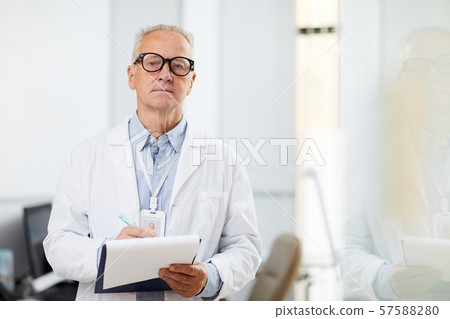 Senior Doctor holding Clipboard Senior Doctor holding Clipboard 57588280