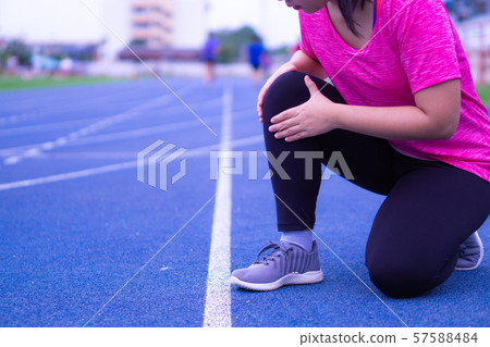 Sport woman holding knee with her hands in pain after suffering muscle injury. Healthcare concept. 57588484