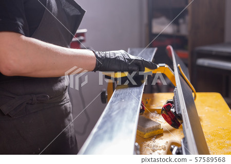 A man repairman in workshop ski service repairing the ski 57589568