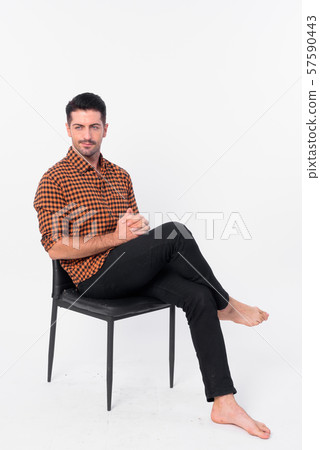 Full body shot of handsome bearded hipster man sitting on chair 57590443