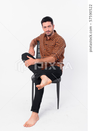 Full body shot of handsome bearded hipster man sitting on chair 57590522