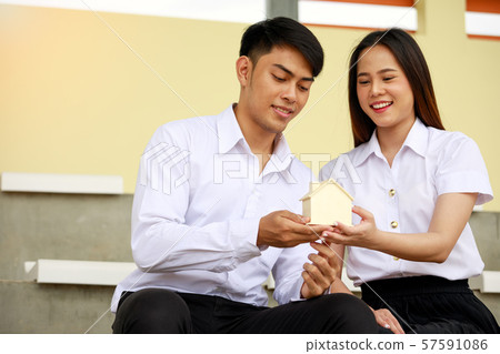 Asia couple of teenage holding house model Asia couple of teenage holding house model 57591086