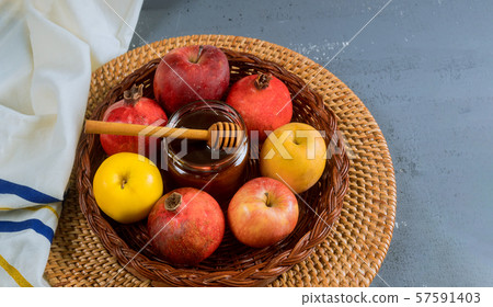 Pouring honey on apple and pomegranate with honey 57591403