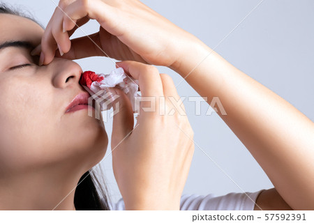 Nosebleed , a young woman with a bloody nose. 57592391
