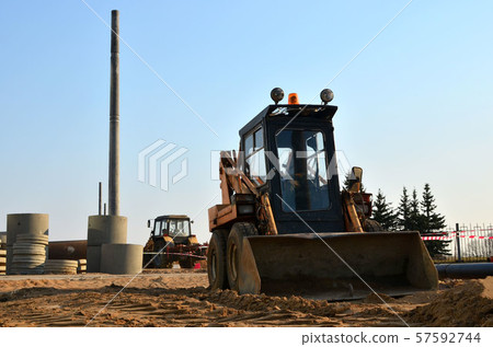 Mini excavator working on a construction site in the city. Mini excavator working on a construction site in the city. 57592744