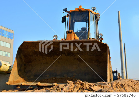 Front-end loader working on construction site during the renovation of the road. Front-end loader working on construction site during the renovation of the road. 57592746