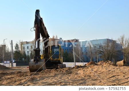 Tracked excavator working at a construction site during laying Tracked excavator working at a construction site during laying 57592755
