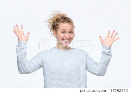 Happy elegant blonde curly girl celebrating her success and looking at camera 57592853