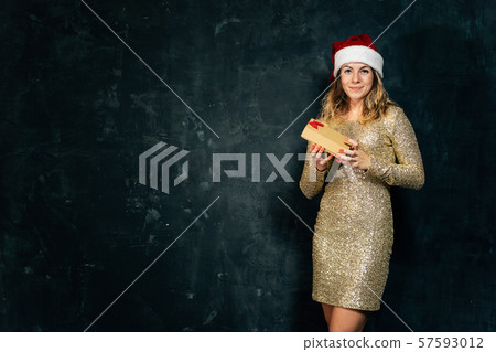 Happy woman with gift box and Santa Claus hat Happy woman with gift box and Santa Claus hat 57593012