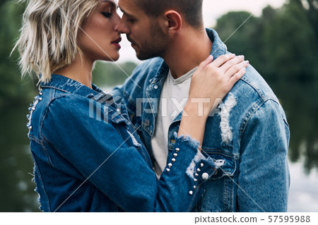 Young loving couple kissing and enjoying the company of each other outdoors Young loving couple kissing and enjoying the company of each other outdoors 57595988
