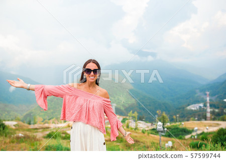 Beautiful happy young woman in mountains in the background of fog 57599744