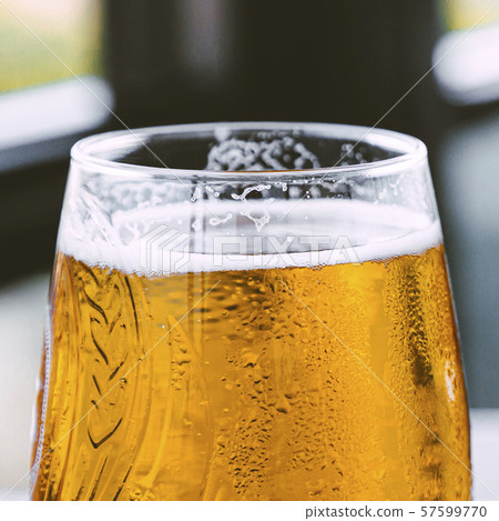 Square closeup photo of glass with golden fresh beer with foam. 57599770