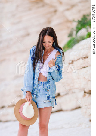 Woman laying on the beach enjoying summer holidays looking at the sea Woman laying on the beach enjoying summer holidays looking at the sea 57599791
