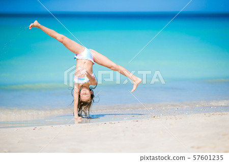 Adorable active little girl at beach during summer vacation Adorable active little girl at beach during summer vacation 57601235