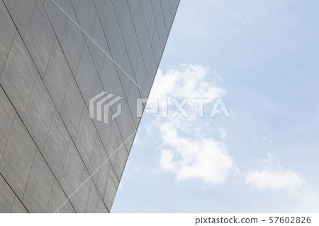 Half view of gray building facade architecture and blue sky on good weather day. 57602826