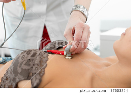 The therapist connects the electrocardiograph 57603234