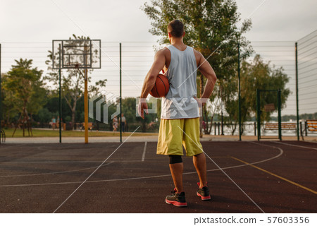 Muscular basketball player on outdoor court Muscular basketball player on outdoor court 57603356
